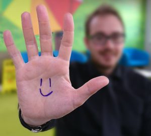 world adoption day smiley on hand