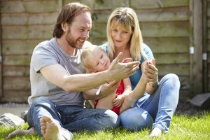 father, mother and adopteddaughter in garden